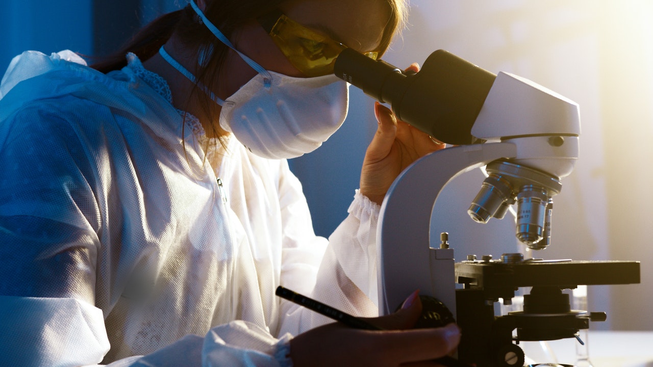 Researcher looking into microscope